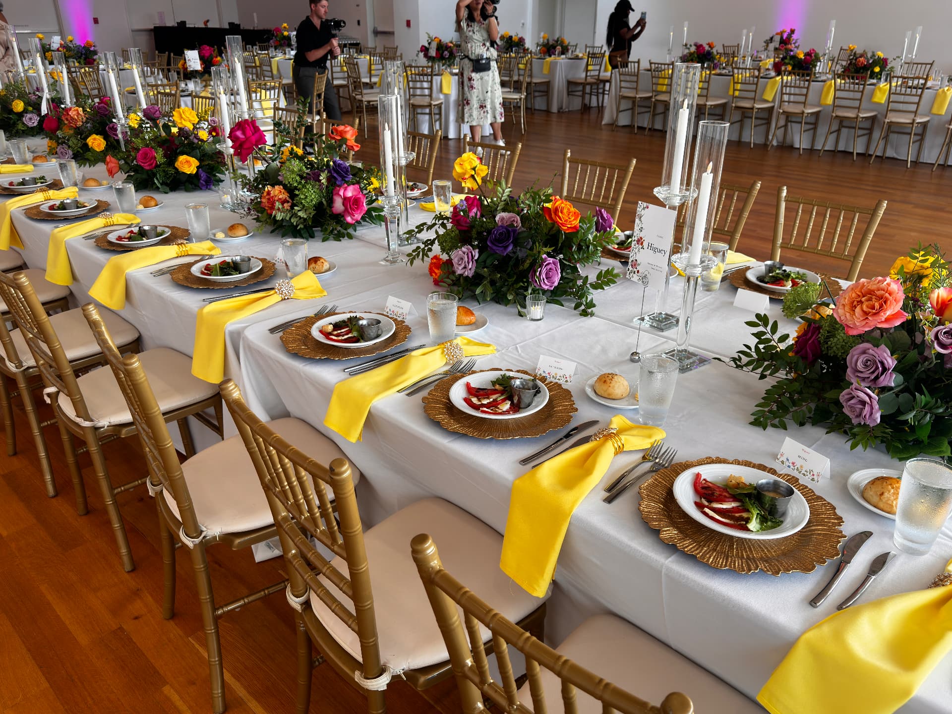 Banquet tables set with gold chargers, tall tapers and low florals — Tablescape & Culinary Presentation by Good Time Mascots in Columbus, Ohio