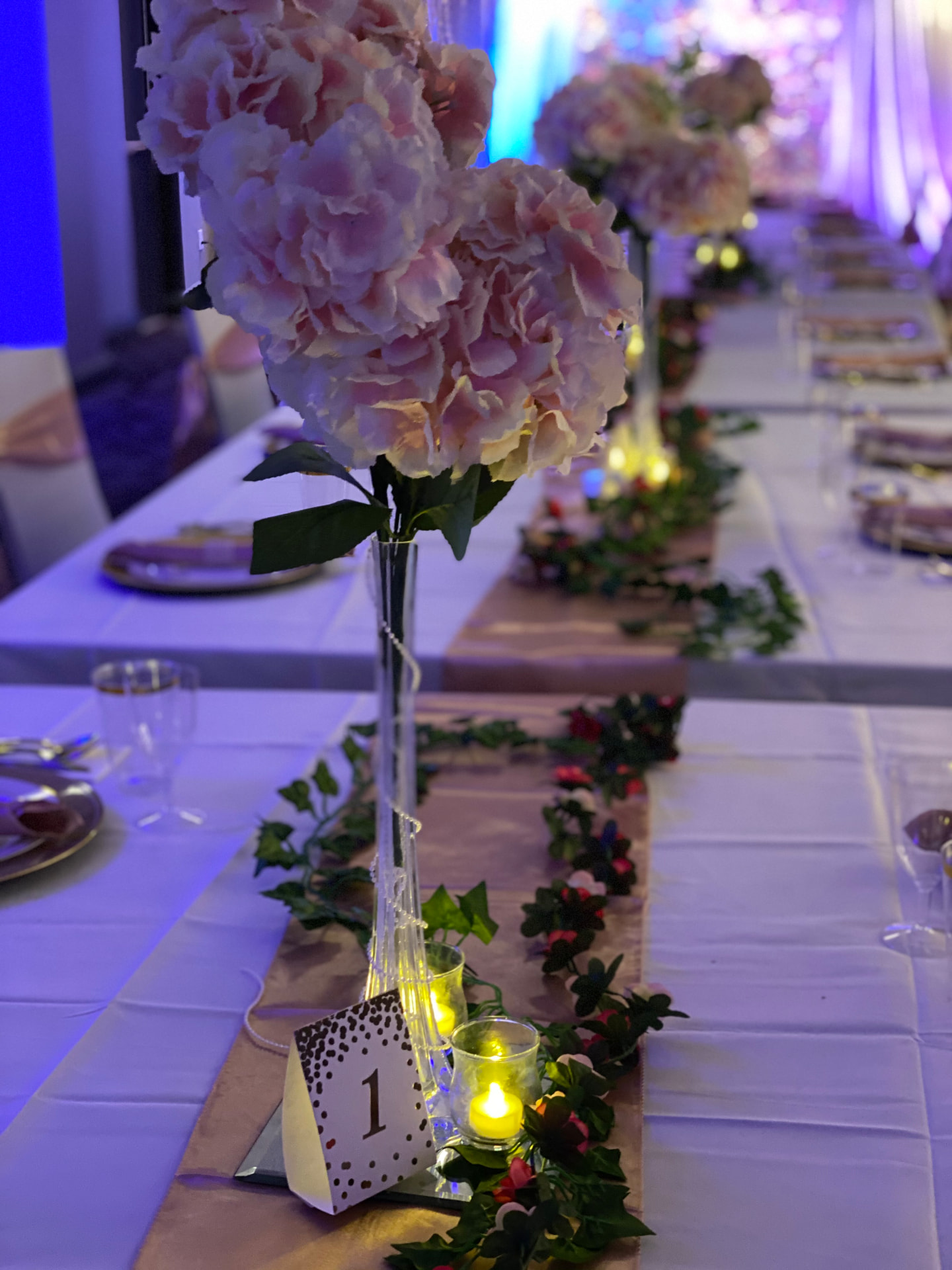 Blush floral centerpiece with garland and candles — Tablescape & Culinary Presentation by Good Time Mascots in Columbus, Ohio