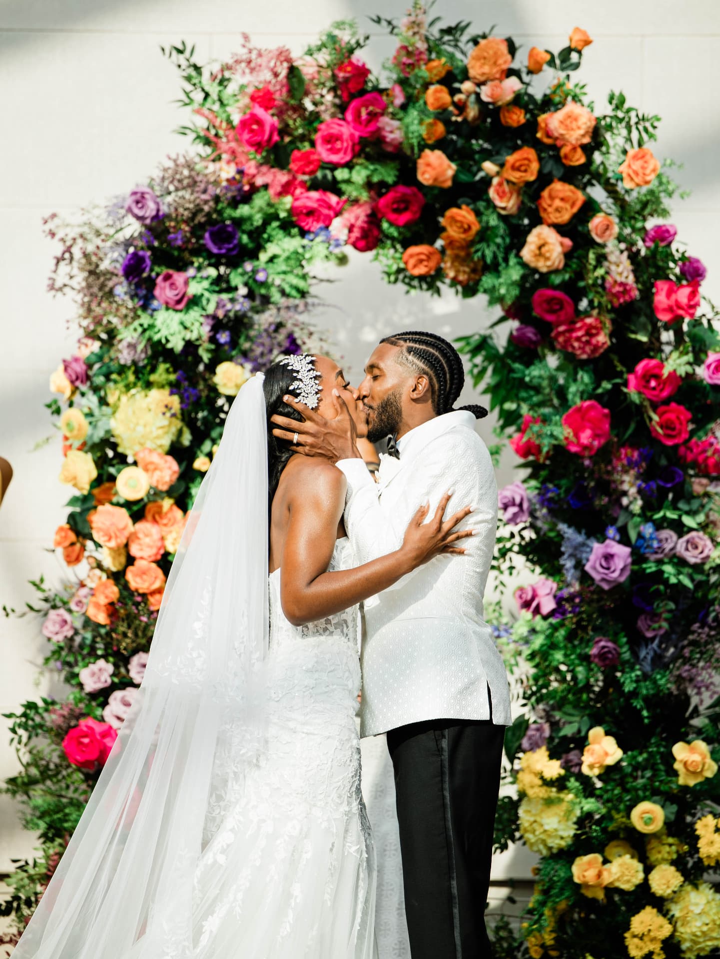 Bride and groom before a full multi-colored floral arch — Weddings by Good Time Mascots in Columbus, Ohio