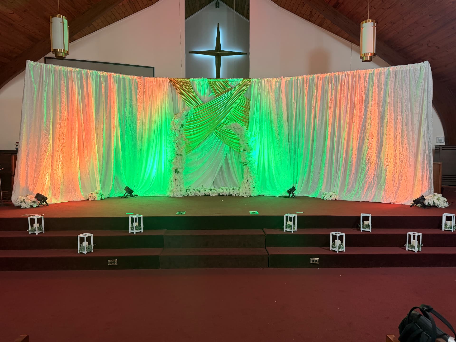 Sanctuary ceremony steps dressed in ivory and gold with a backlit cross — Weddings by Good Time Mascots in Columbus, Ohio