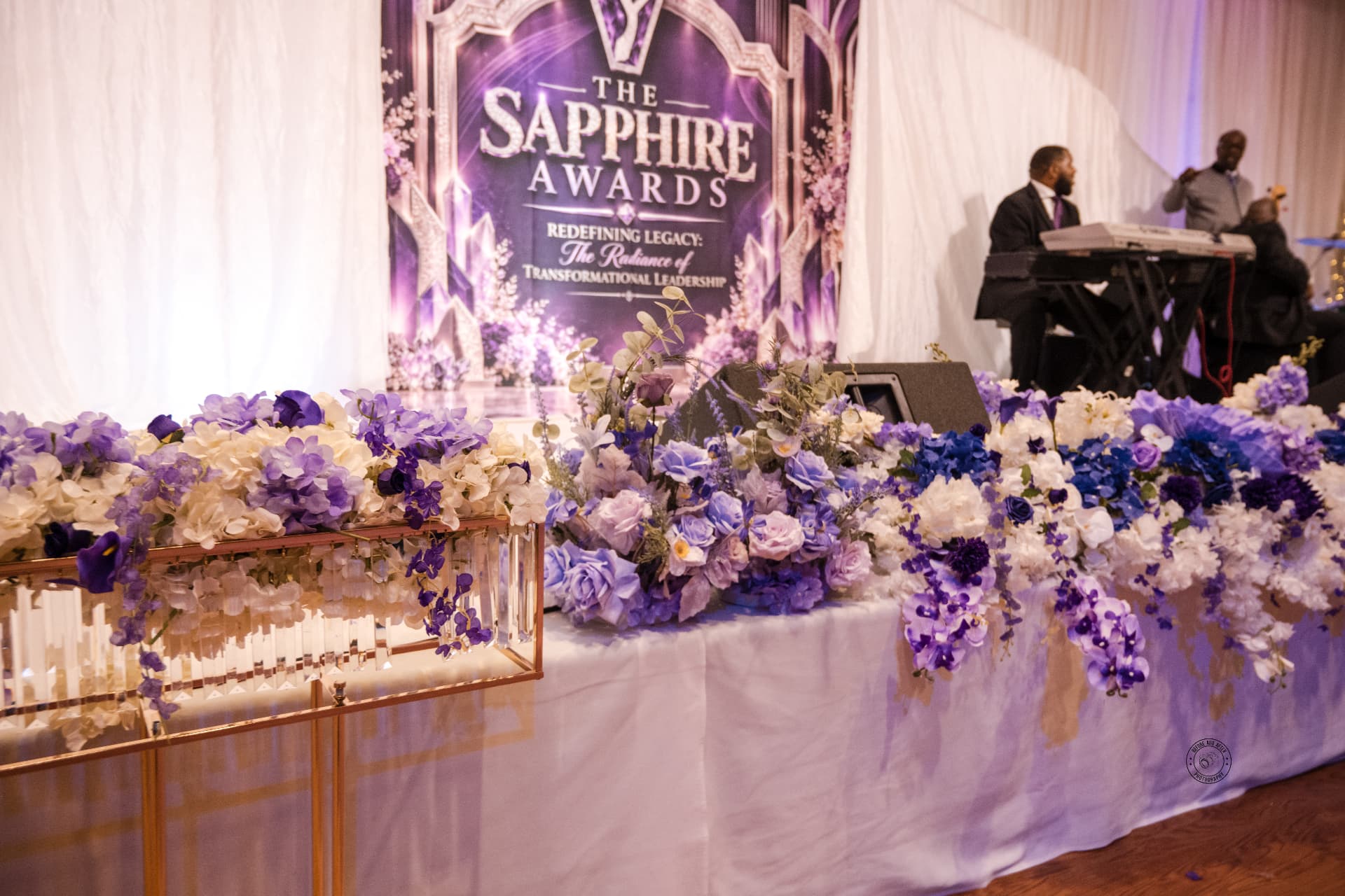 Gala stage backdrop framed by head-table florals — Stage & Presentation Experiences by Good Time Mascots in Columbus, Ohio