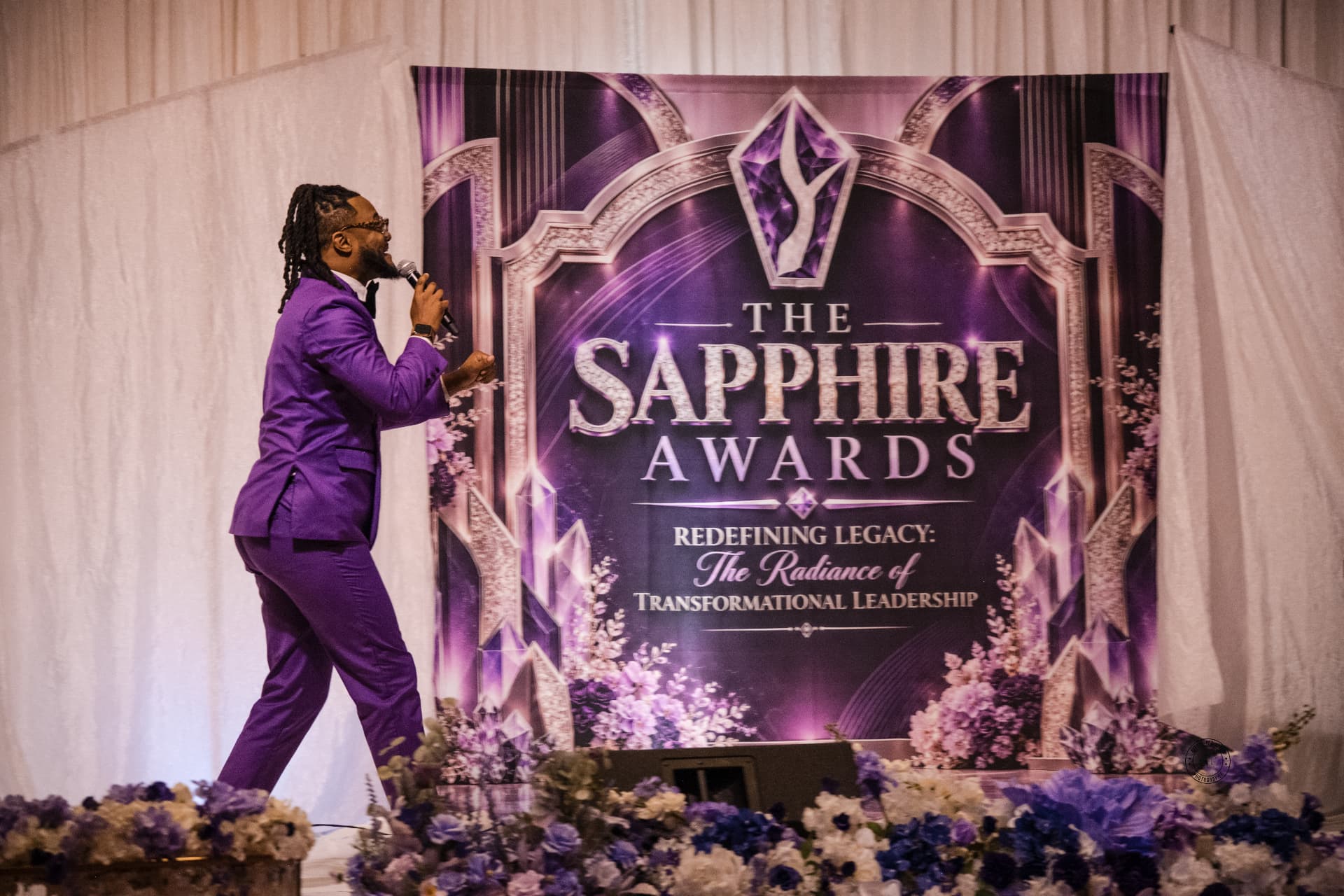 Emcee on stage before a custom Sapphire Awards backdrop — Stage & Presentation Experiences by Good Time Mascots in Columbus, Ohio