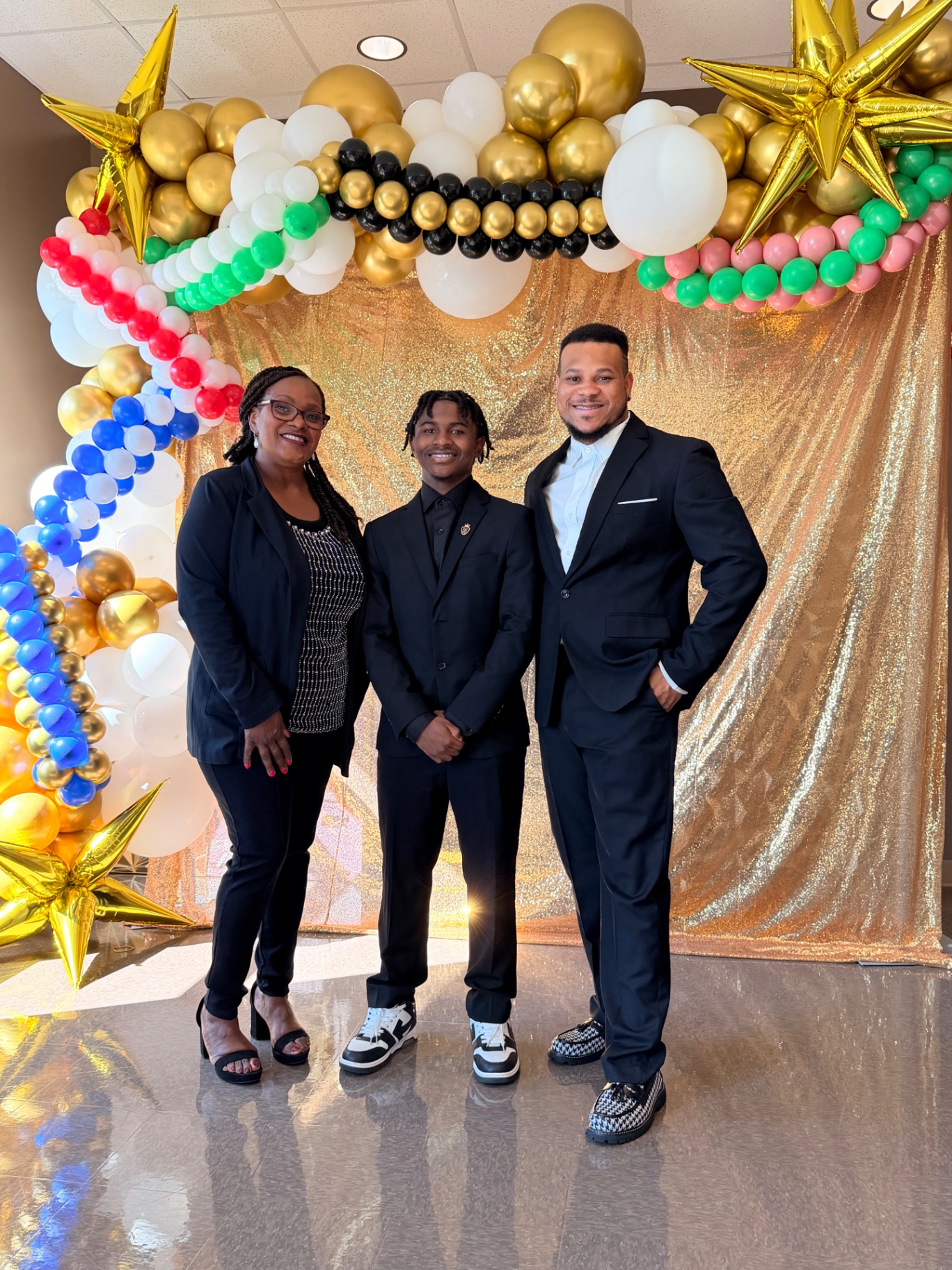 The Good Time Mascots family in front of a custom gold balloon arch